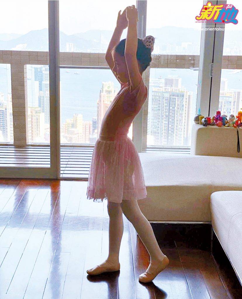  芭蕾美少女背後是落地玻璃、巨型露台和維港無敵海景，簡約布藝梳化上放滿Sofia的小玩具、獨角獸，非常溫馨。
