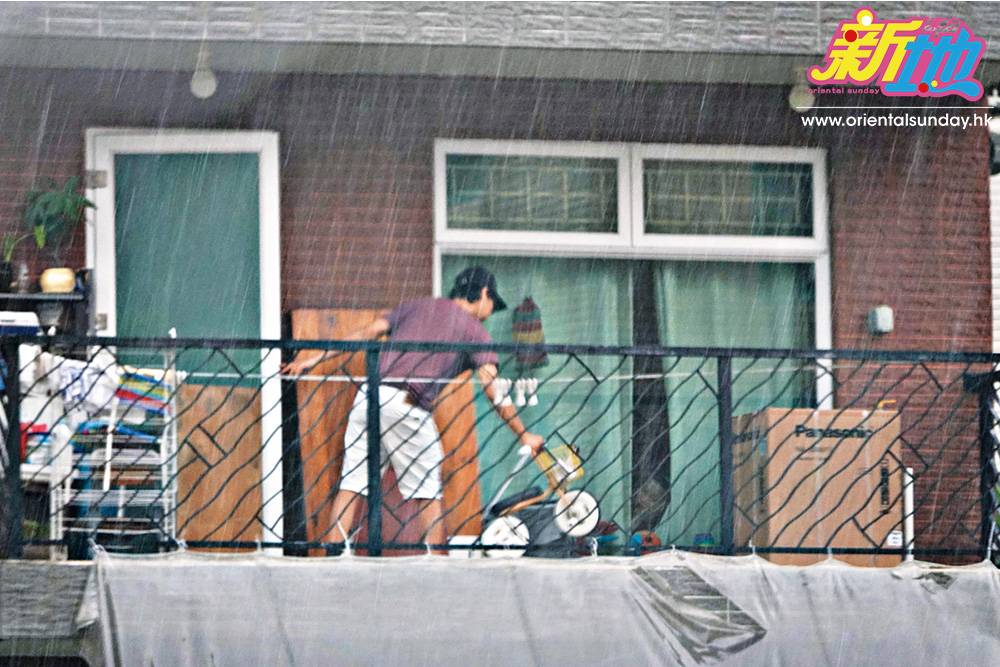  送貨工人前腳一走，便下起滂沱大雨，梁子峰急忙將原先放出露台外的囝囝單車收起放入屋。