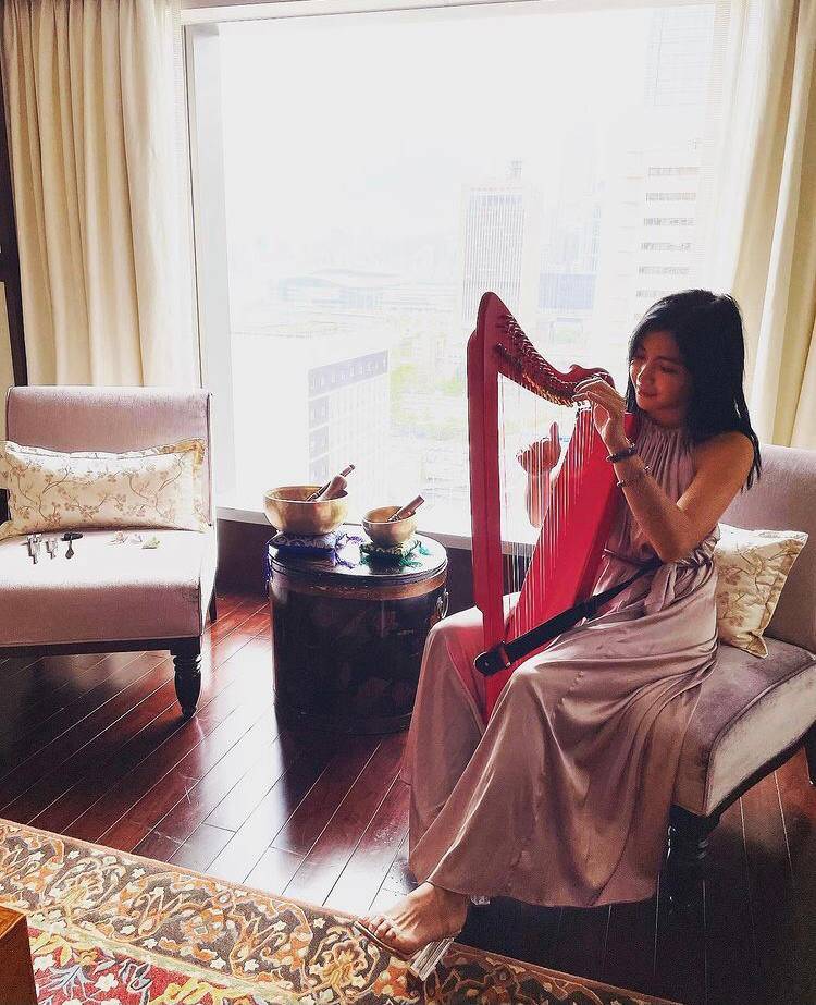  陳偉琪上載於酒店套房彈豎琴的照片。