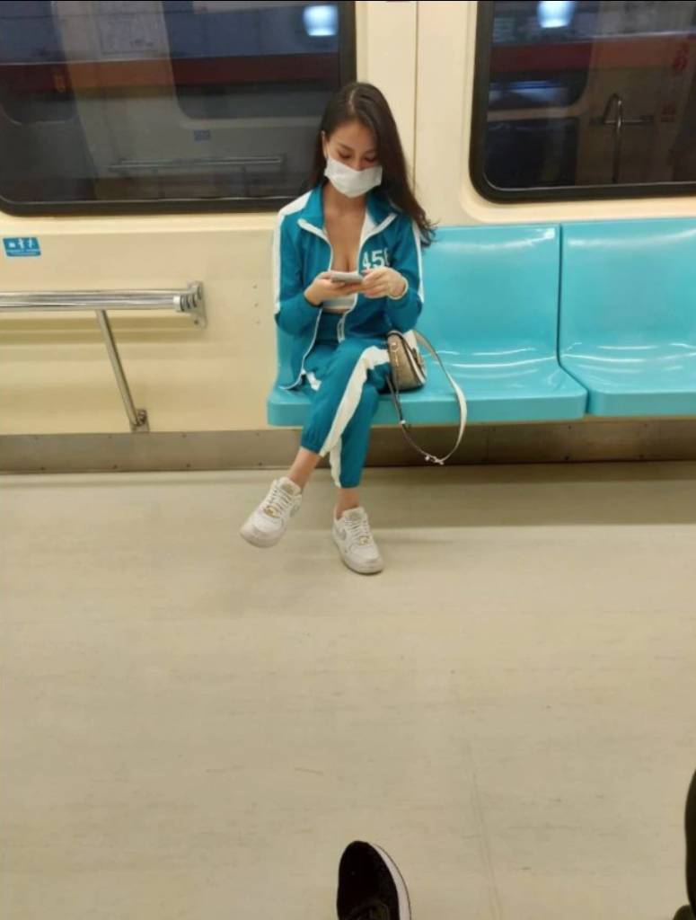 魷魚遊戲 有台灣網友早前在Facebook社團《爆廢公社二館》發文，在捷運上發現一名辣妹，穿上《魷魚遊戲》主角穿的「456」編號藍色運動服，令人眼前一亮。