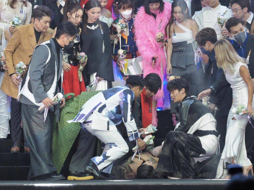 鍾雨璇在大合照暈倒在地上。（圖片來源：TVB 娛樂新聞台 TVB Entertainment News）