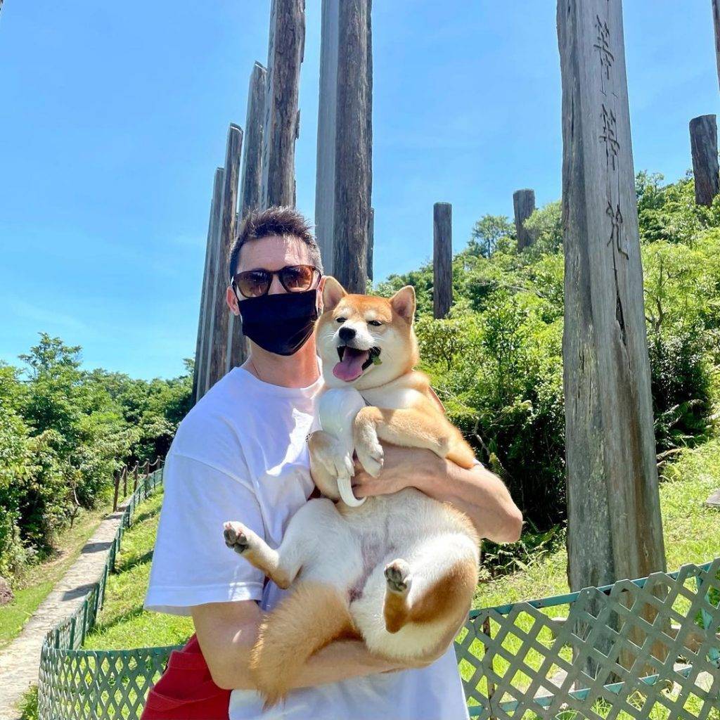 張曦雯男朋友Mark[抱起愛犬Nala，在心經簡林郊遊拍照。