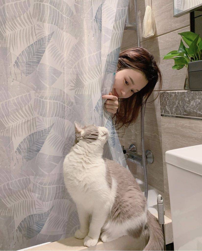 李蔓瑩 在浴簾後伸出頭來的Renee與愛貓相映成趣。