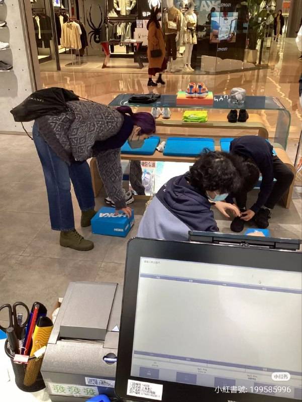 楊千嬅 女店員從收銀機位置影過去，楊千嬅仲幫忙執鞋盒。