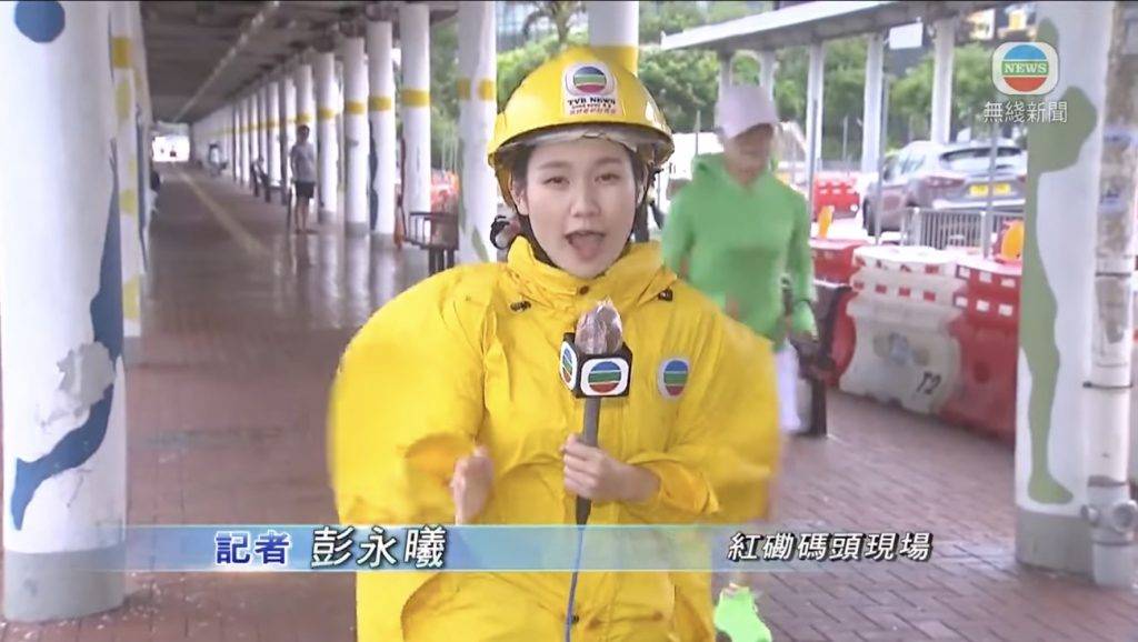 TVB女記者 但當佢講到被風吹到行唔到亦企唔穩時，身後有多個途人輕鬆跑過。