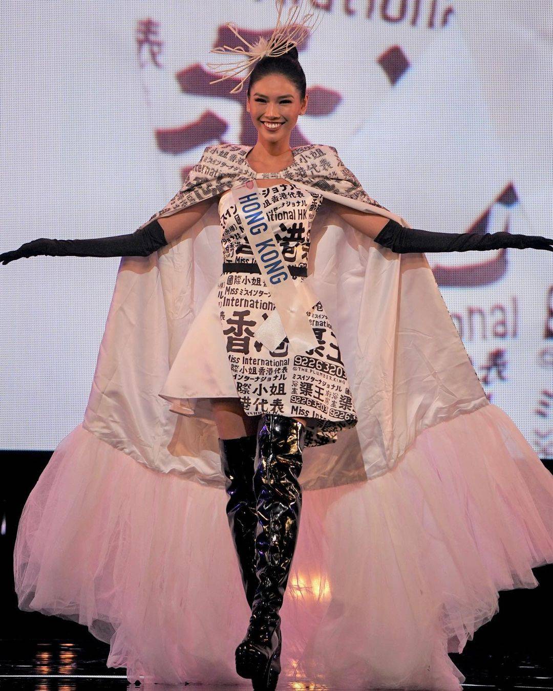 梁庭欣 而上屆國際小姐香港代表菀蔚所著嘅民族服飾，就以黑白街招廣告作為設計元素。