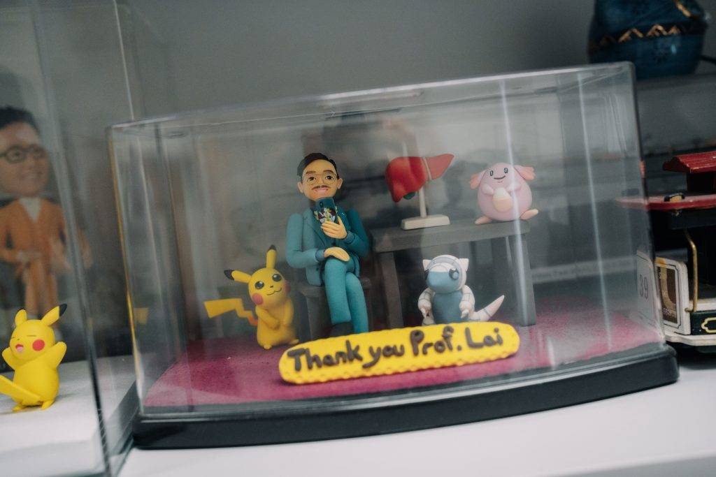 黎青龍辦公室裡擺滿學生送來的小精靈擺設和畫作,甚至將他繪成與比卡超並肩的漫畫角色。(圖片來源:黃志宏攝)