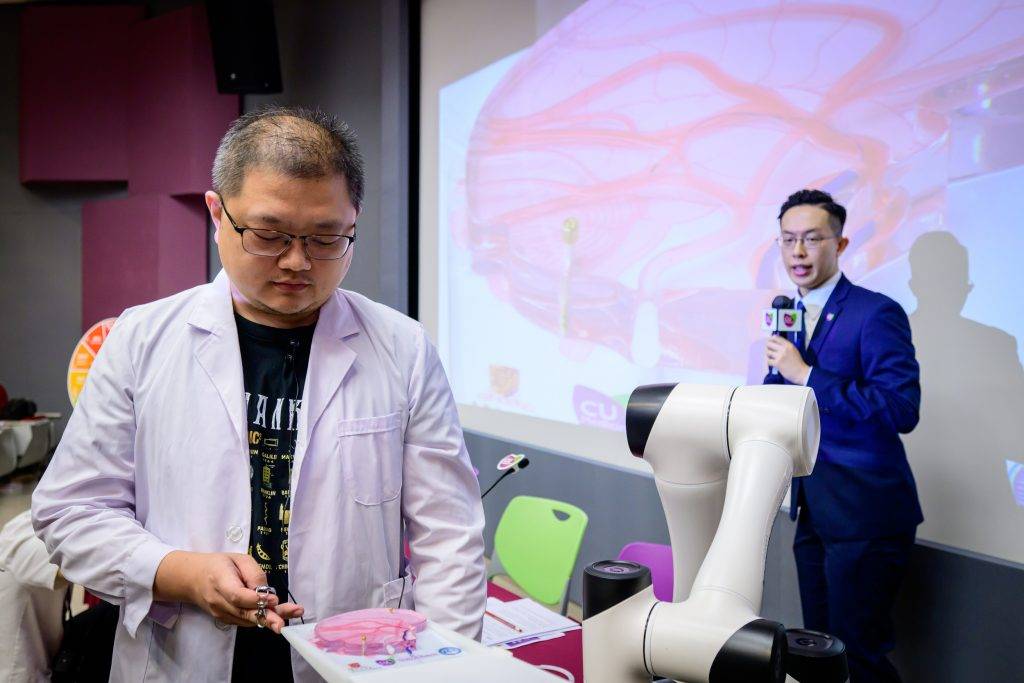 中大研發全球首款磁控螺旋微導管 助治中遠端腦 (左一)是次研究第一作者張沫艽博士及陳啟楓教授示範如何將磁控軟性螺旋微導管引導至複雜的腦血管結構,減少對脆弱腦血管的損傷。(圖片來源:中大醫學院)